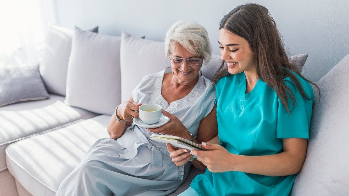 A caregiver and senior preparing a healthy meal together in a bright kitchen
